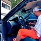 Foto de Neymar Jr dentro de Range Rover Fisrt Edition preta, usando boné branco, blusa branca e bermuda laranja