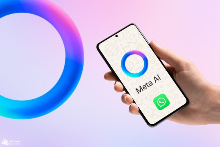 A imagem mostra uma mão segurando um smartphone. Na tela, há um círculo colorido em tons de azul e rosa, com as palavras "Meta AI" abaixo. O ícone do WhatsApp está localizado na parte inferior. O fundo é suave, em tons de rosa e azul, complementando as cores do círculo.