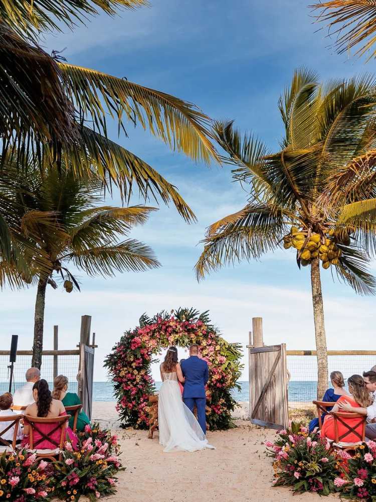 Mulher vestida de noiva e homem de terno azul casando em Trancoso 