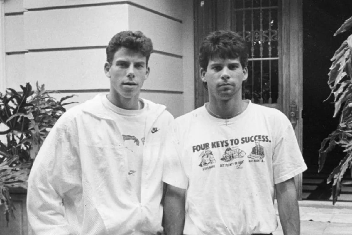 Foto em preto e branco de irmãos Menendez em frente à mansão