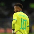 Foto de Neymar diagonal usando camisa amarela da Seleção Brasileira, segunda pele amarela e expressão triste