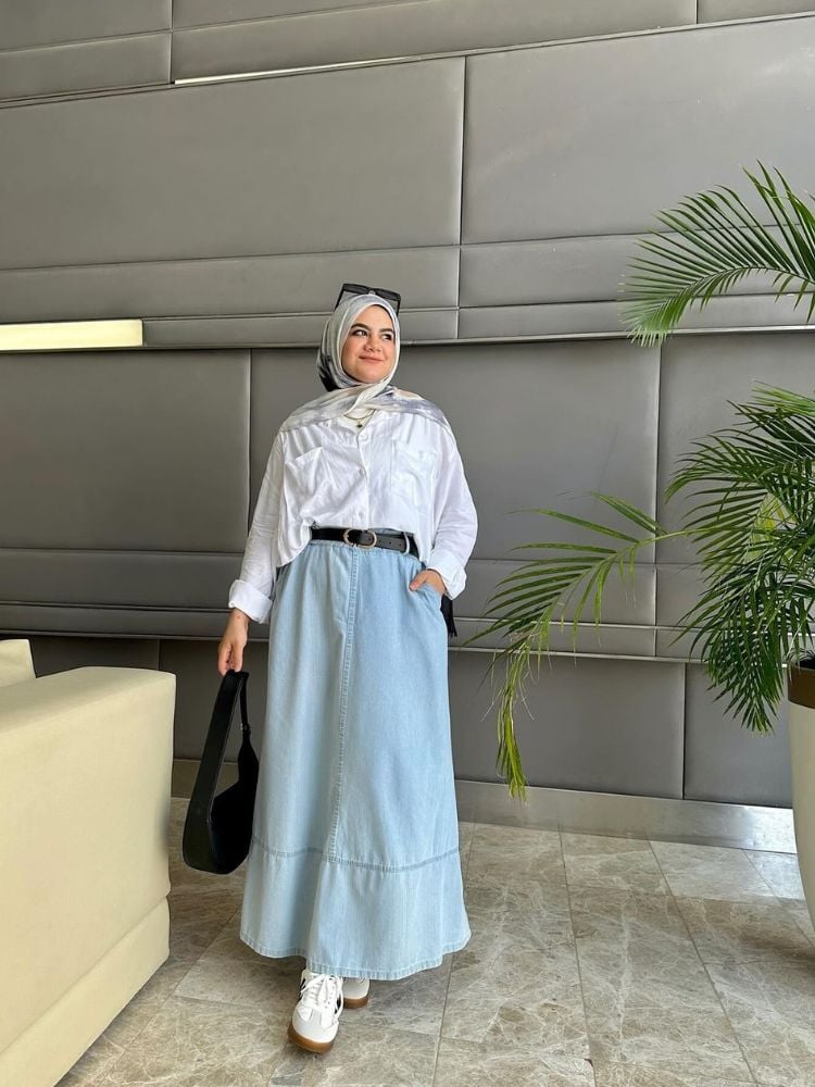 Mulher com hijab, camisa branca, saia longa jeans