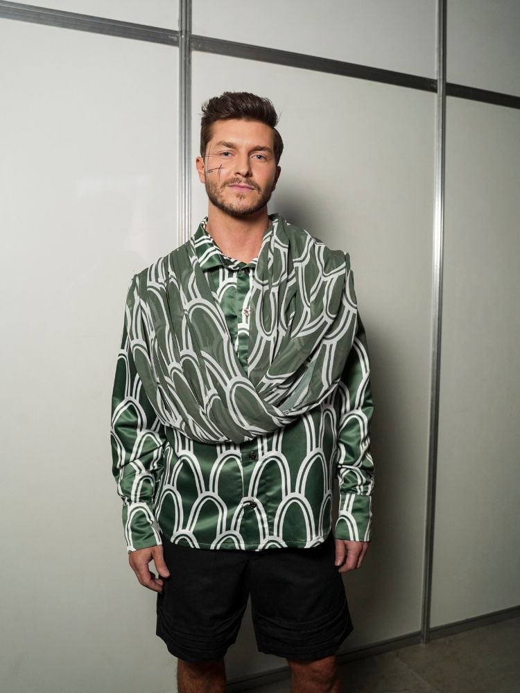 Kléber Toledo usando blusa verde estampada de orelha de Sansão e bermuda preta