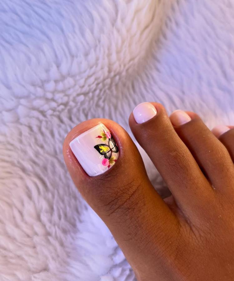 Pés com unhas decoradas com adesivo de borboleta