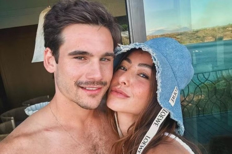 Foto de Nicolas Prattes e Sabrina Sato. Ele está sem camisa e ela usa um bucket hat jeans