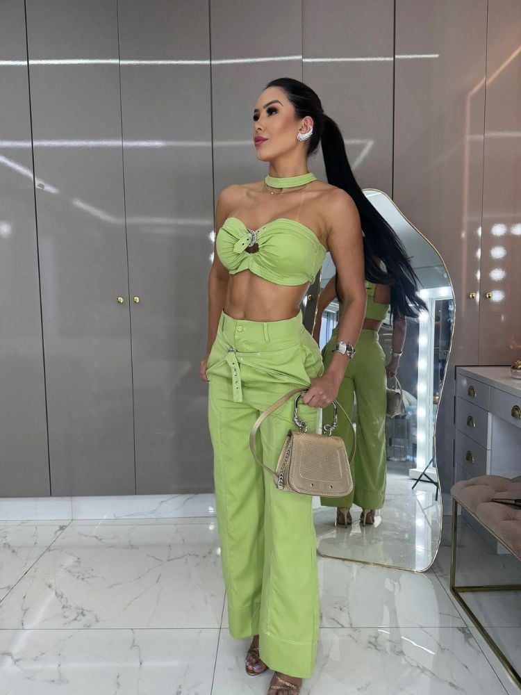 Mulher de pele clara usando top e calça verdes-claro