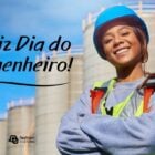 Mulher usando capacete de segurança azul e colete refletor amarelo e laranja. Ao lado, lemos "Feliz Dia do Engenheiro"