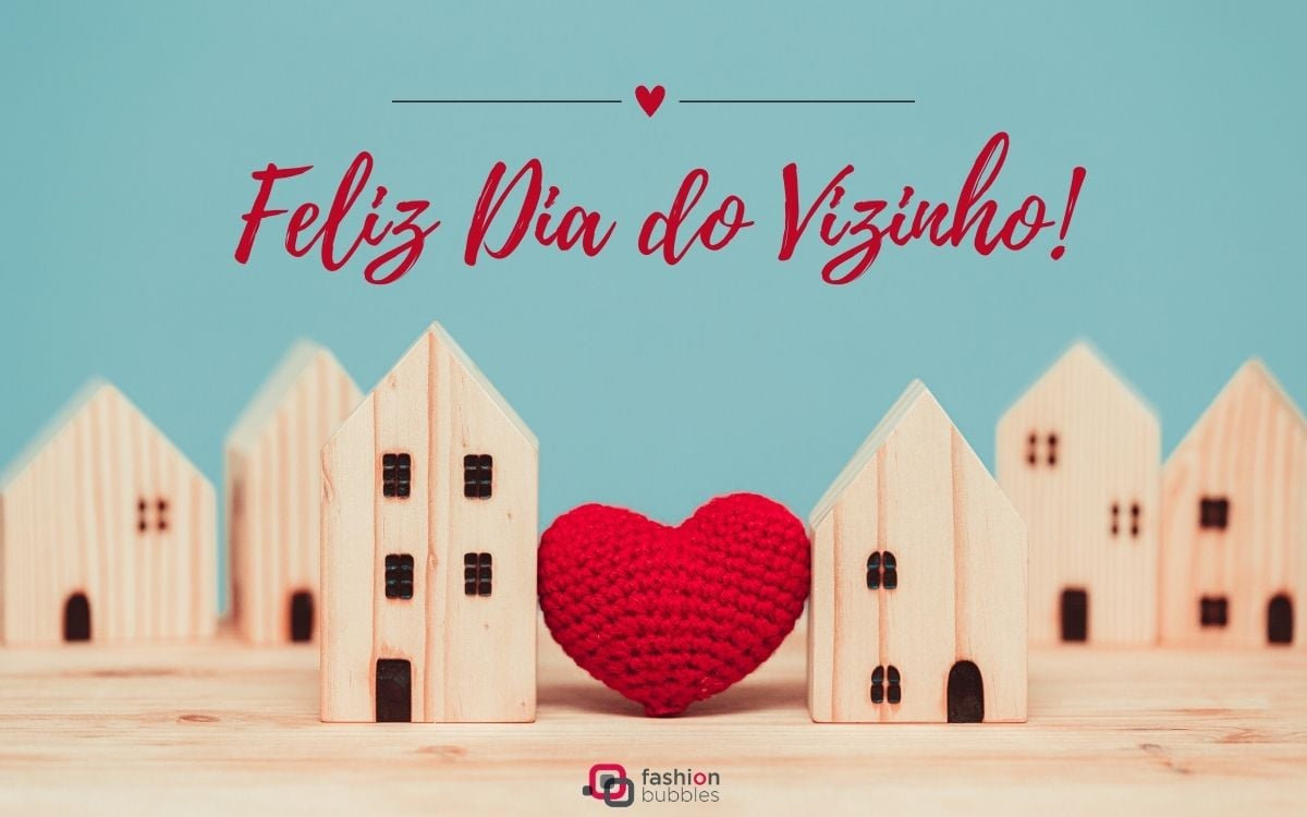 Foto de casas de madeira ligadas por um coração de crochê. Acima, lemos "Feliz Dia do Vizinho"