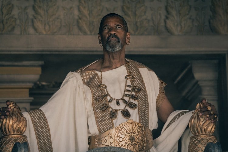 Denzel Washington usando roupa branca com acessórios, típico vestuário romano