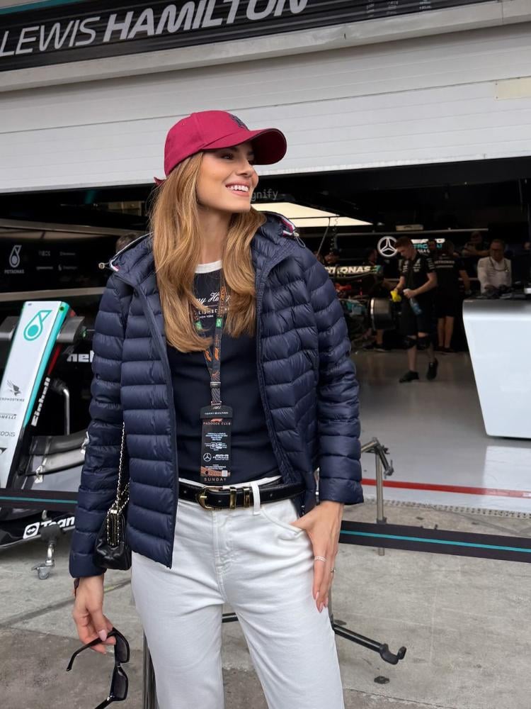 Camila Queiroz usanco boné vinho, blusa azul marinho, jaqueta puffer azul marinho e calça branca