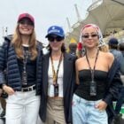 Foto de Camila Queiroz usando look azul marinho e branco, Alice Wegmann usando look com cores neutras e Julia Rodrigues usando look preto e jeans abraçadas