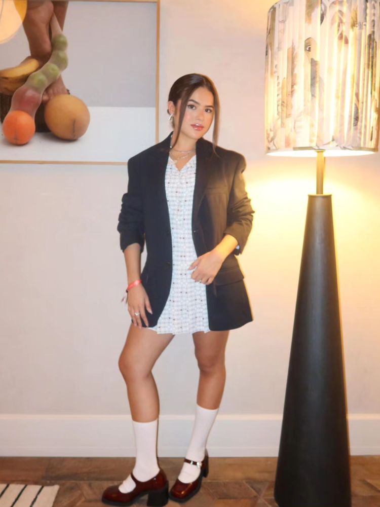 Maisa Silva usando vestido branco, blazer cinza, meia cano longo e sapatilha 