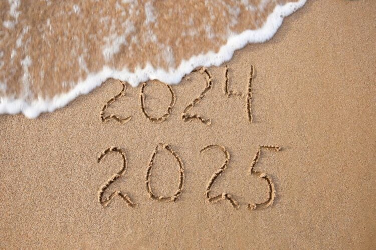 Escrito 2024 e 2025 na areia de praia com onda cobrindo parte de 2024. Retrospectiva 2024